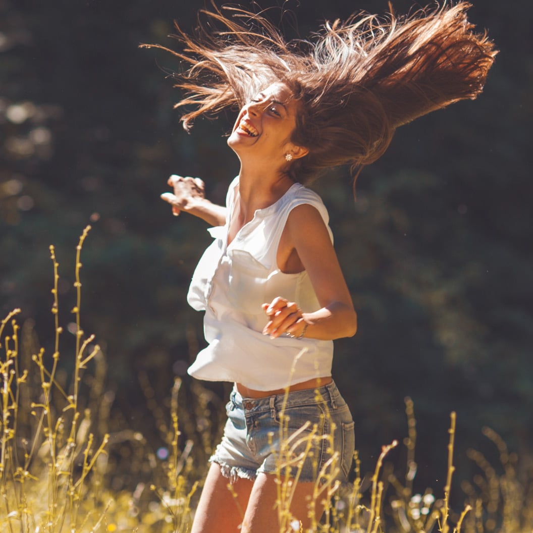 Image of happy woman dancing in a field